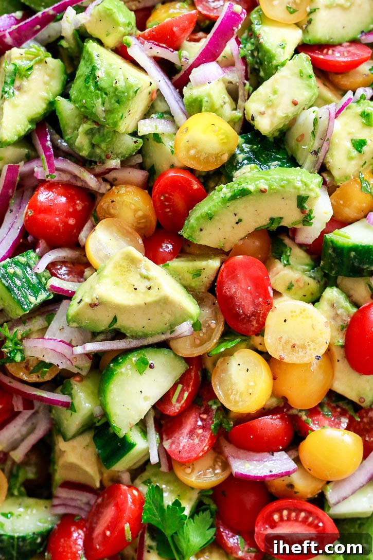 A beautifully presented, simple avocado salad brimming with vibrant tomatoes, fresh cucumber, and thinly sliced red onion, exquisitely dressed in a bright mustard vinaigrette. This healthy and easy-to-make salad is a delight for any meal.