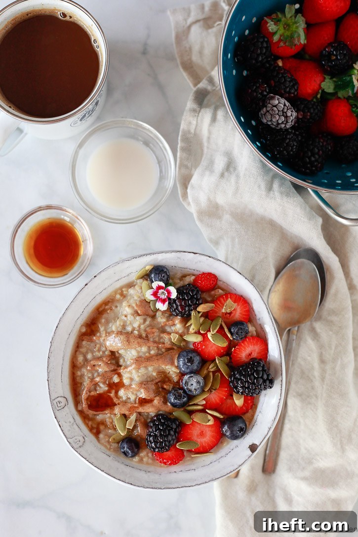 A beautiful bowl of steel cut oats with almond butter, maple syrup, and fresh berries, ready for a cozy breakfast. Made easily in a slow cooker or Instant Pot.