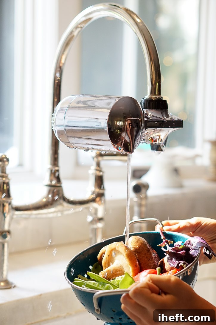 Rinsing fresh vegetables for a delicious curry soup with a PUR water filter system, ensuring clean and pure ingredients.