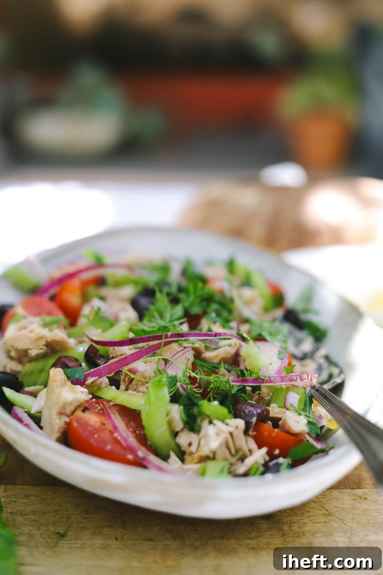 Mediterranean tuna salad Mediterranean tuna salad with albacore tuna, cherry tomatoes, celery, red onion, kalamata olives, and fresh parsley in a shallow bowl.