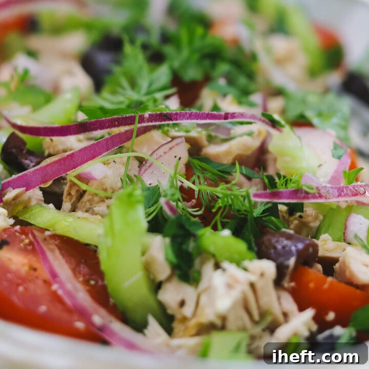 Mediterranean Tuna Salad with Olives and Lemon Vinaigrette 2 close-up of a Mediterranean tuna salad recipe with cherry tomatoes, red onion, celery, and herbs.
