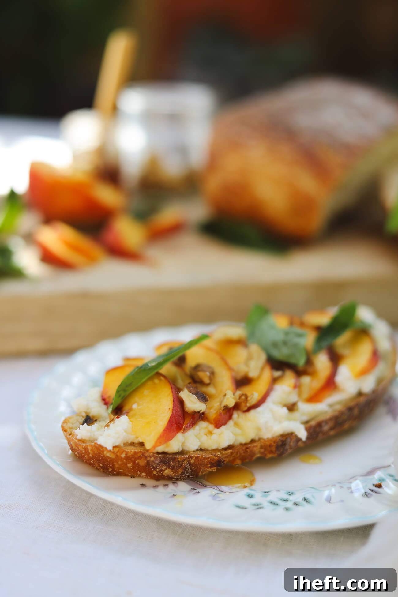 Peach Ricotta Toast Recipe Peach ricotta toast with whipped honey ricotta, fresh peaches, basil, walnuts, and honey on homemade sourdough.